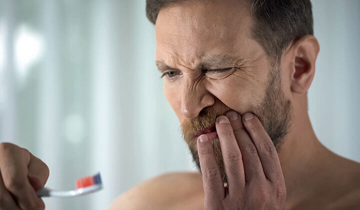 Mann mit Zahnfleischbluten 