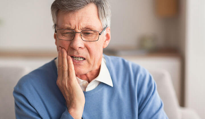 Mann mit Druckstellen durch Zahnprothese      