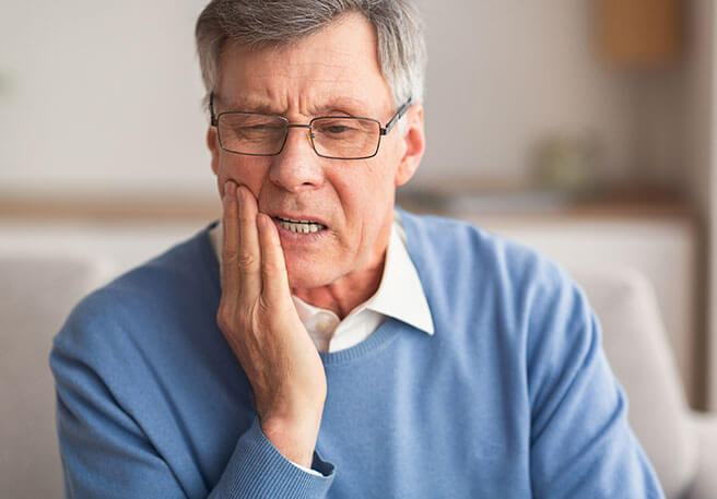 Mann mit Druckstellen durch Zahnprothese 